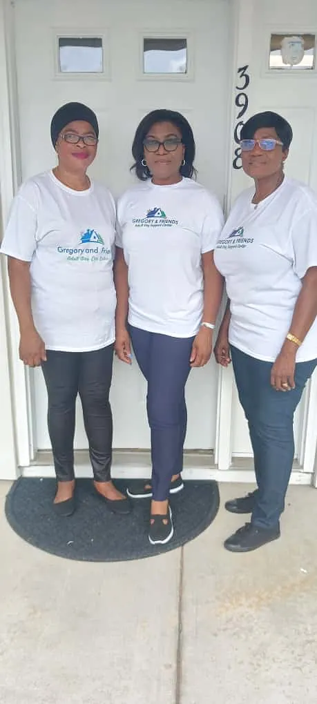 The Gregory & Friends team in branded shirts standing together at the center entrance