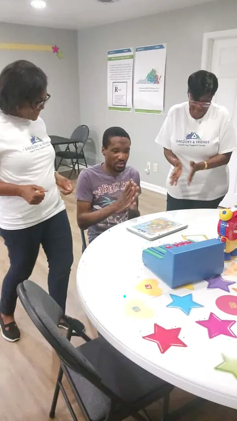 Staff celebrating with a participant during a group activity at the center