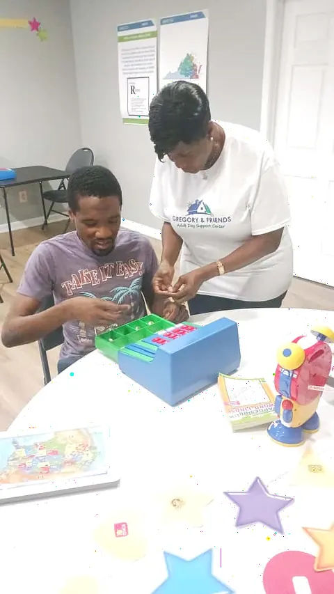 A caregiver helping a participant work through a fine-motor sorting activity